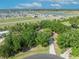 Aerial view of a home surrounded by trees, with a distant view of lakes and neighborhood at 2810 Windsong Ln, St Cloud, FL 34772