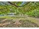 Spacious backyard with a lush lawn and mature trees, perfect for outdoor activities at 2810 Windsong Ln, St Cloud, FL 34772