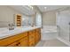 Bright bathroom featuring double sinks, a soaking tub, glass shower, and ample storage at 2810 Windsong Ln, St Cloud, FL 34772