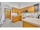 Kitchen with wood cabinets, white appliances, and tile floors at 2810 Windsong Ln, St Cloud, FL 34772