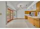 Bright kitchen features wood cabinets, tile floors, stainless refrigerator, and glass patio doors at 2810 Windsong Ln, St Cloud, FL 34772