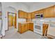 Kitchen with wood cabinets, tile floors, and white appliances at 2810 Windsong Ln, St Cloud, FL 34772