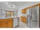 Kitchen featuring wood cabinets, tile floors, and stainless steel refrigerator at 2810 Windsong Ln, St Cloud, FL 34772