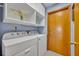 Bright laundry room features a washer and dryer, storage cabinets, and a painted accent wall at 2810 Windsong Ln, St Cloud, FL 34772