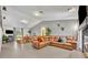 Spacious living room with a large brown sectional, wood dining table, tile floors, and neutral paint at 2810 Windsong Ln, St Cloud, FL 34772
