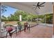 A cozy screened porch with tiled flooring, comfortable chairs, and a ceiling fan at 2810 Windsong Ln, St Cloud, FL 34772