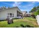 View of backyard, showing the house and screened patio area and lush green grass at 2848 Wilshire Rd, Clermont, FL 34714