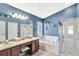 This primary bathroom includes double sinks, a soaking tub, and a standing shower behind a glass door at 2848 Wilshire Rd, Clermont, FL 34714