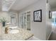 Bright bathroom with a granite countertop, a decorative mirror, and a view to the pool area at 3306 Fishermans Cv, Winter Park, FL 32792