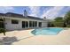 Back of house featuring a backyard pool with sliding glass doors and concrete deck at 3306 Fishermans Cv, Winter Park, FL 32792