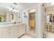 Bright bathroom featuring double vanity with marble countertop, white cabinets, and glass enclosed shower at 35 Misners Trl, Ormond Beach, FL 32174