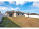 Backyard with fenced perimeter, partial grass, and beige-colored home with dark roof at 3761 Shoveler Ave, Leesburg, FL 34748