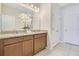 Bathroom with dual sinks, granite countertops, and neutral-toned cabinets and floors at 3761 Shoveler Ave, Leesburg, FL 34748