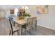 Dining room with nice floors and a table set for four with the kitchen in the background at 3761 Shoveler Ave, Leesburg, FL 34748