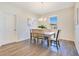 Well-lit dining room with wood floors, a modern chandelier, and a view of the backyard at 3761 Shoveler Ave, Leesburg, FL 34748