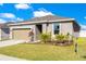 Single story home with two car garage, lawn and nice landscaping around the front entrance at 3761 Shoveler Ave, Leesburg, FL 34748