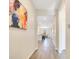 Hallway with wood floors leading to an open-concept living area with a table and chairs at 3761 Shoveler Ave, Leesburg, FL 34748