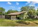 Back exterior featuring a screened-in porch, well-maintained lawn, and green paint at 3790 Ne 22Nd Ave, Ocala, FL 34479