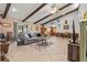 Spacious living room featuring tile floors, beamed ceilings, and seamless transition to the dining area at 3790 Ne 22Nd Ave, Ocala, FL 34479