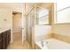 Relaxing bathroom with a soaking tub, glass-enclosed shower, and neutral tile finishes at 3812 Creswick Cir, Orlando, FL 32829