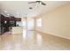 Open-concept living room with tile flooring, ceiling fan, and kitchen with stainless appliances in the background at 3812 Creswick Cir, Orlando, FL 32829