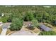 Aerial view of a home with a long driveway surrounded by dense trees and neighboring houses at 4 Starling Dr, Daytona Beach, FL 32117