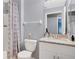 Clean bathroom with gray walls, featuring a shower, toilet, and vanity with ample storage at 4 Starling Dr, Daytona Beach, FL 32117