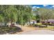 Well-maintained home with mature trees, a blue garage door, and a neatly paved driveway at 4 Starling Dr, Daytona Beach, FL 32117