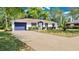 Well-kept single-story home with a spacious driveway and manicured bushes, offering a welcoming curb appeal at 4 Starling Dr, Daytona Beach, FL 32117