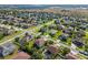 An aerial view pinpoints a home in a suburban community, surrounded by well-maintained lawns and streets at 4113 Longbow Dr, Clermont, FL 34711