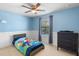Bright bedroom with colorful bedding, a ceiling fan, and a dark wood dresser at 4113 Longbow Dr, Clermont, FL 34711