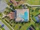 An aerial view of a community pool with a unique shape, surrounded by lounge chairs and palm trees at 4113 Longbow Dr, Clermont, FL 34711
