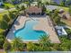 Aerial view of community pool with lounge area, playground and bathrooms surrounded by lush greenery at 4113 Longbow Dr, Clermont, FL 34711
