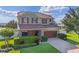 Charming two-story home with a well-manicured lawn, brick-paved driveway and mature landscaping at 4113 Longbow Dr, Clermont, FL 34711