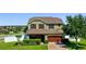 Charming two-story home featuring manicured landscaping, a brick driveway, and a two-car garage at 4113 Longbow Dr, Clermont, FL 34711