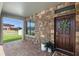 Inviting front porch with stone accents, decorative wreath, and beautiful tile flooring at 4113 Longbow Dr, Clermont, FL 34711