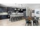 Modern kitchen features dark cabinets, stainless steel appliances, a large island with seating at 4113 Longbow Dr, Clermont, FL 34711