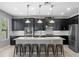 Modern kitchen with dark cabinets, stainless appliances, a large island, and barstool seating at 4113 Longbow Dr, Clermont, FL 34711