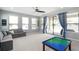 Cozy living room featuring a comfortable sectional sofa, ceiling fan, and access to the outdoor patio at 4113 Longbow Dr, Clermont, FL 34711