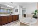 A large main bathroom boasts a double sink vanity, a soaking tub, and a separate shower area at 4113 Longbow Dr, Clermont, FL 34711