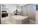 The main bathroom features a soaking tub and a glass-enclosed shower with light tile and dual windows at 4113 Longbow Dr, Clermont, FL 34711