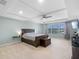 Spacious main bedroom with a tray ceiling, a large window, and a beautiful wooden bed frame at 4113 Longbow Dr, Clermont, FL 34711