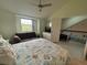 Bright bedroom with a comfortable couch, ceiling fan and view from the window at 4244 Sun Village Ct # 160, New Smyrna Beach, FL 32169