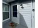Home's porch with a white door, grey siding, an outdoor light fixture, and a cute welcome mat at 4244 Sun Village Ct # 160, New Smyrna Beach, FL 32169