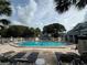 Large community pool with lounge chairs and palm trees at 4244 Sun Village Ct # 160, New Smyrna Beach, FL 32169