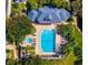 Aerial view of a community pool, spa, lounge chairs, and well maintained landscaping and greenery at 4244 Sun Village Ct # 160, New Smyrna Beach, FL 32169