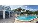 Community pool surrounded by palm trees with building in the background at 4244 Sun Village Ct # 160, New Smyrna Beach, FL 32169
