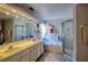 This bathroom offers dual sinks, an integrated bathtub, and a glass door shower at 4381 Creekside Blvd, Kissimmee, FL 34746