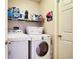Practical laundry room equipped with a washer, dryer, storage shelf and plenty of cleaning supplies at 4381 Creekside Blvd, Kissimmee, FL 34746