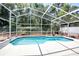 Enjoy this beautiful screened-in pool with an outdoor area surrounded by lush greenery at 4381 Creekside Blvd, Kissimmee, FL 34746